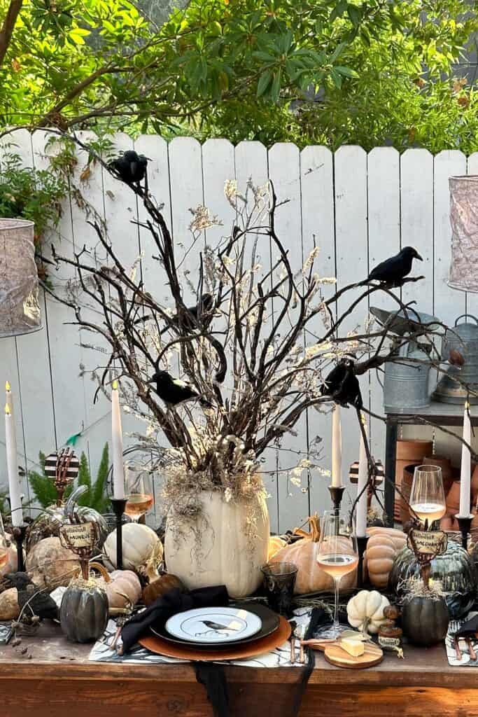 A Halloween tree made in a fake pumpkin vase with black crows
