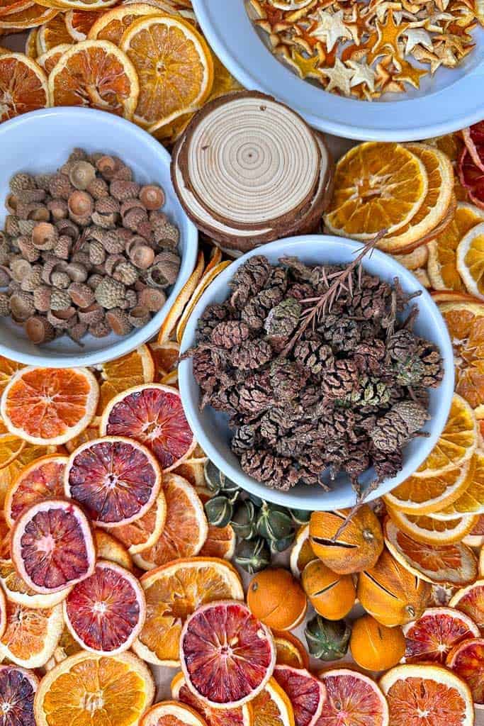Supplies needed to make Dried orange ornaments. dried oranges, pinecones, acorns, anise star  
