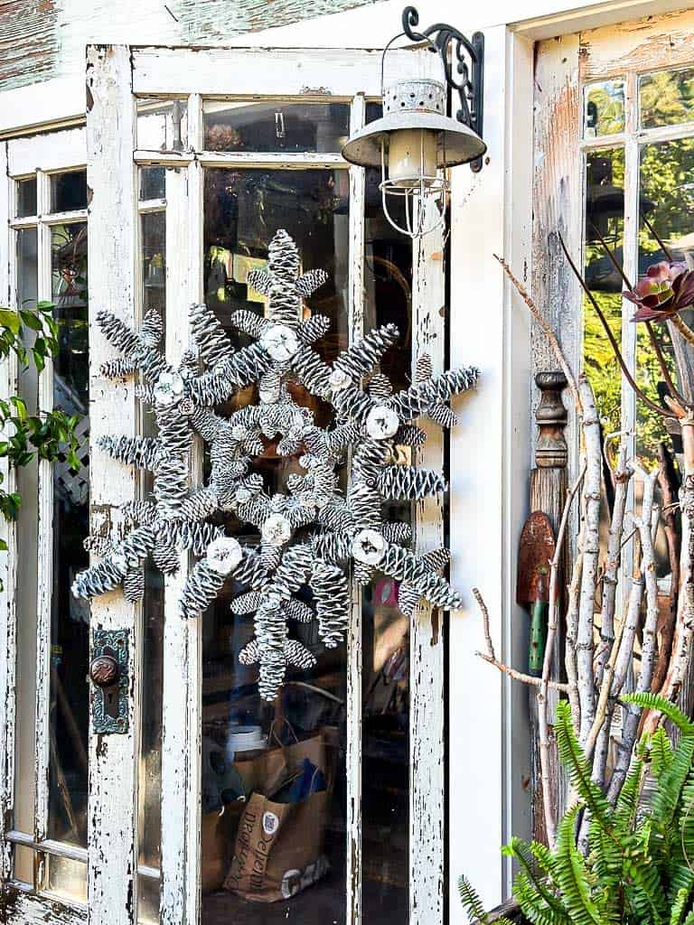 Pinecone wreath hanging on A She-shed door which is open.