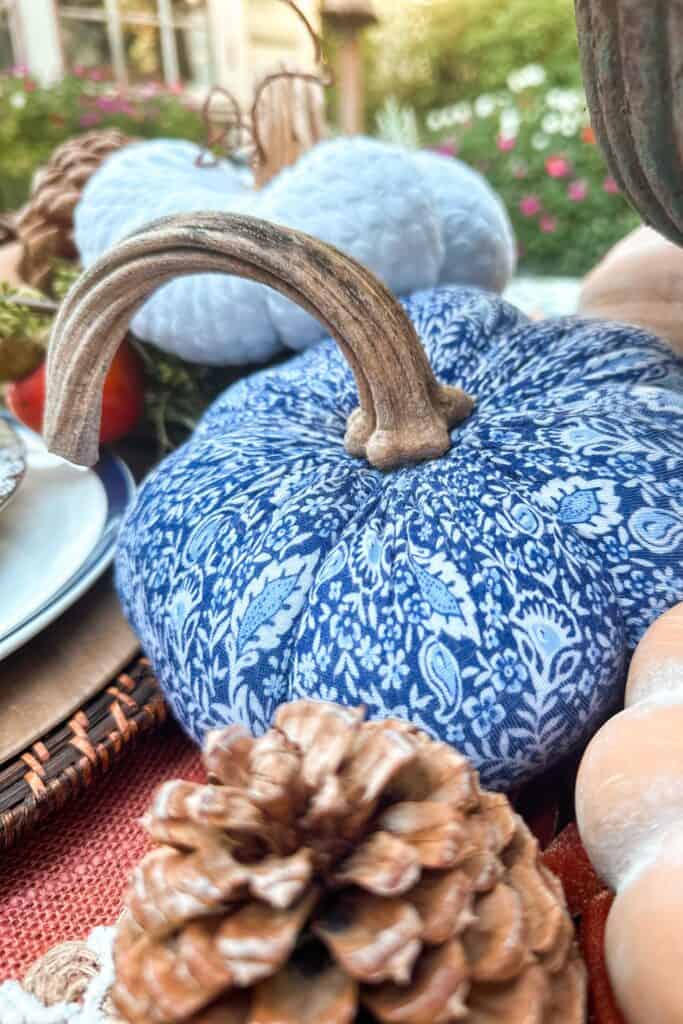 Handmade blue and white fabric pumpkin sitting on a Thanksgiving table