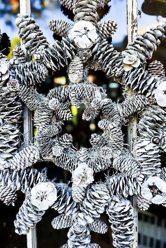 A frosted pine cone snowflake wreath up close image of the center.