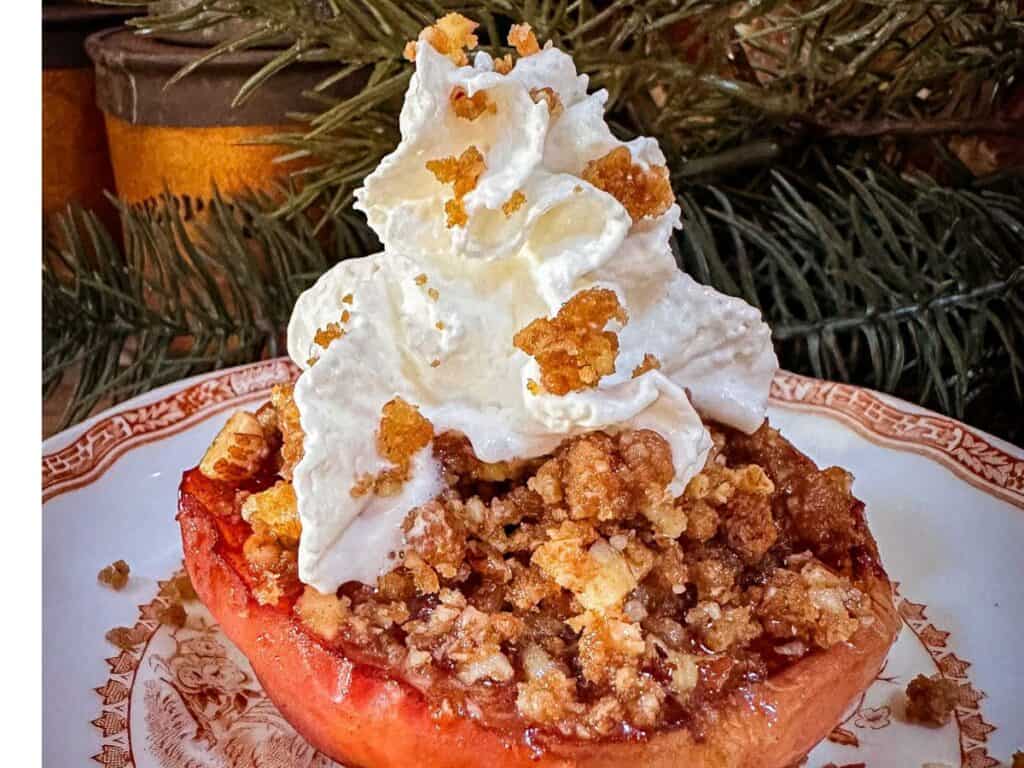 Baked apple on a plate served with whipped cream and gingersnap crumble