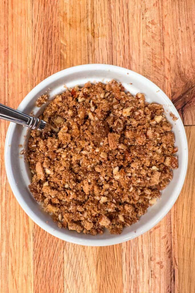 Brown sugar, pecans, and gingersnaps are crushed to make a crumble topping for baked apples.
