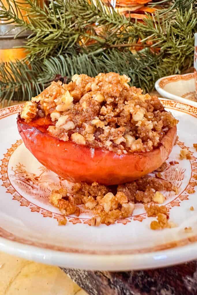 Baked apple with crumble topping served on a fall plate for dessert.