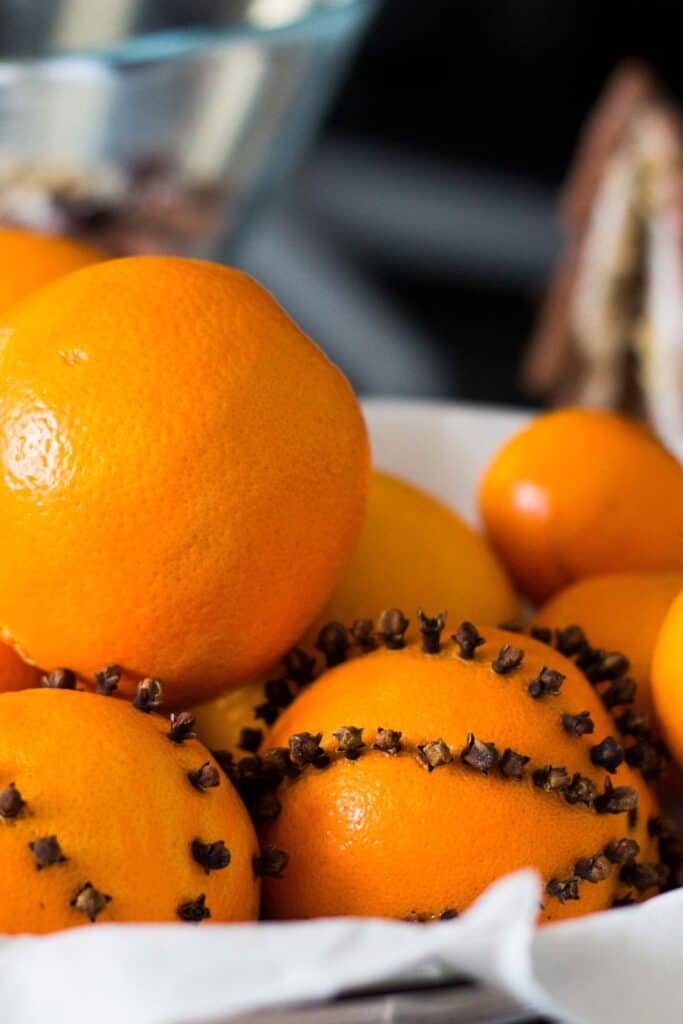 oranges in a bowl decorated with cloves for holiday decoration 