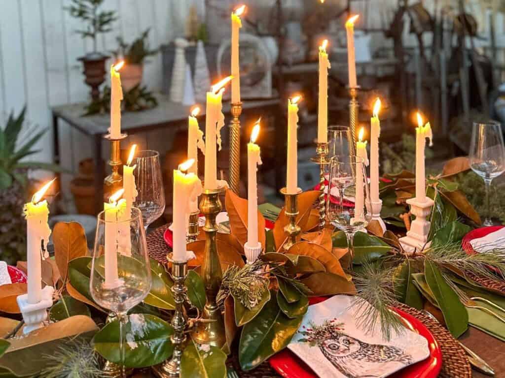 A rustic tablescape set with tons of candles and fresh greens cut from the tree.