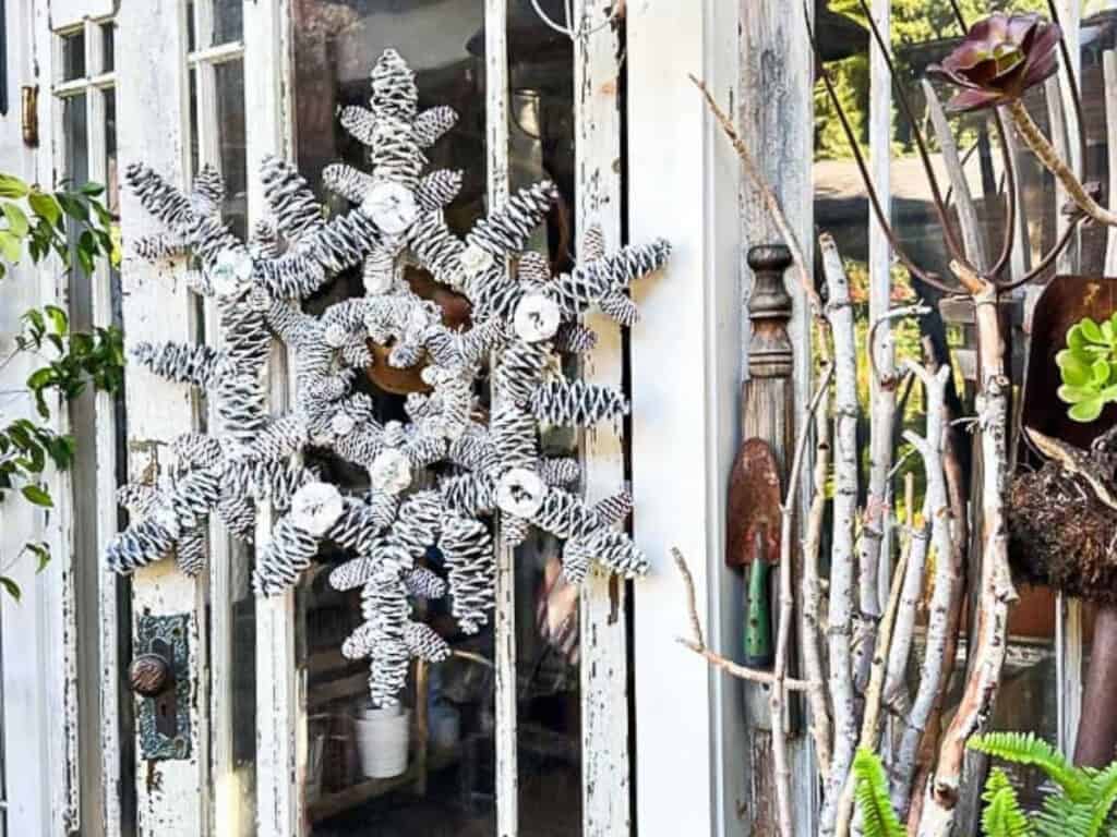 pinecone snowflake wreath hanging on a door