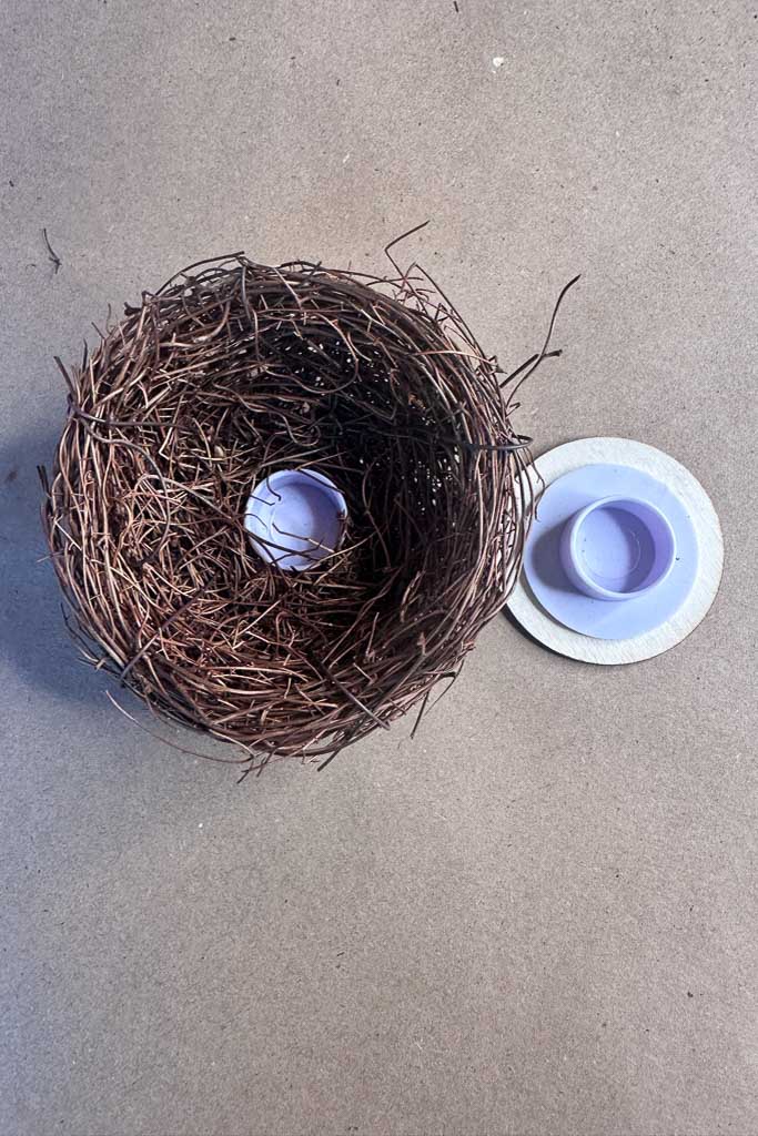 A bird's nest is glued to a wood disk to create a small candle lamp.