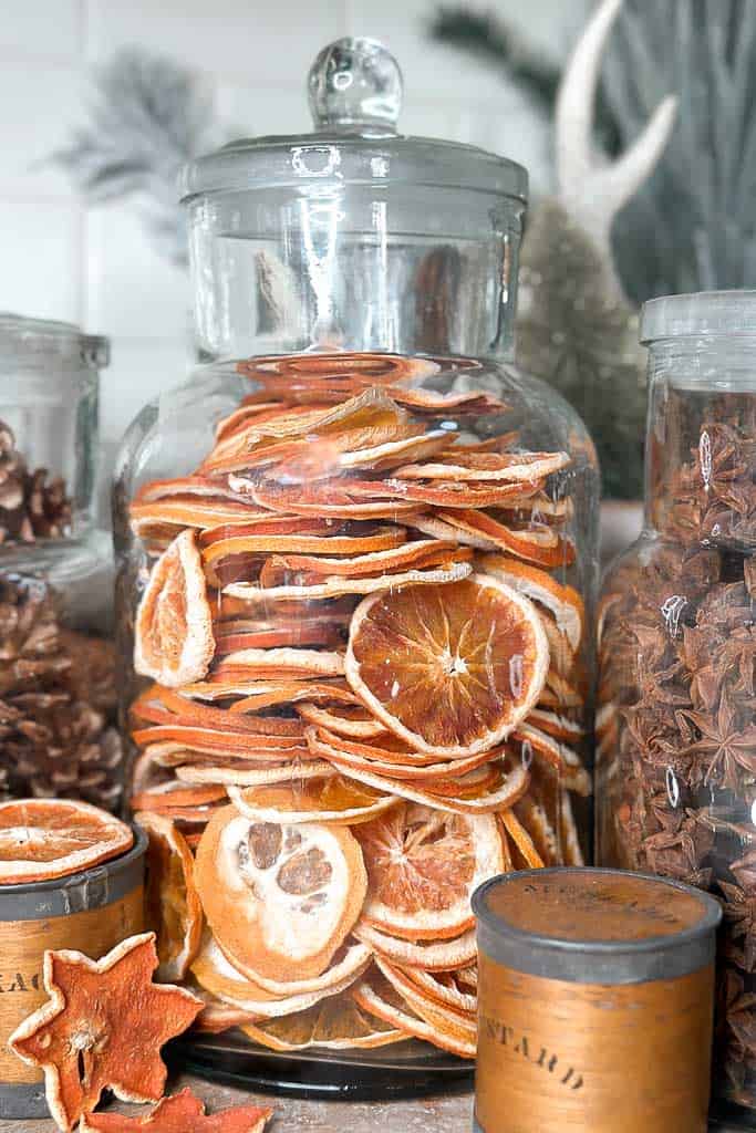 Apothecary jar filled with dried oranges.