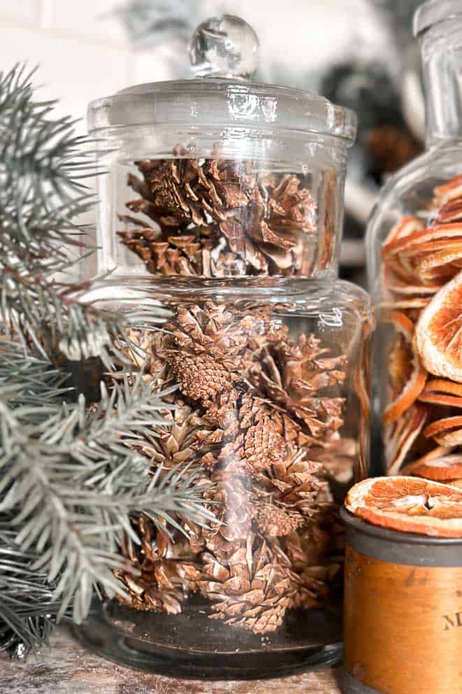 Apothecary jars filled with pinecones for Christmas.