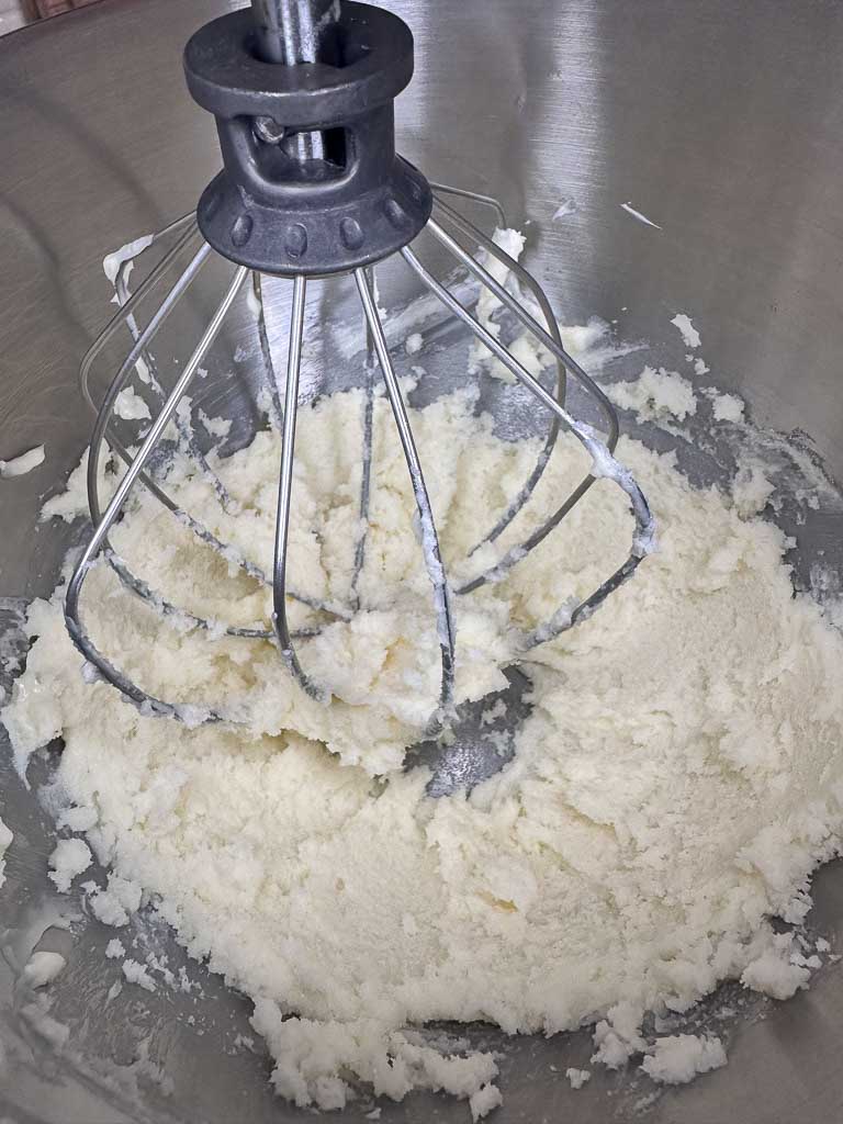 The mixing of butter and sugar together in the Kitchenaid mixer to soften.