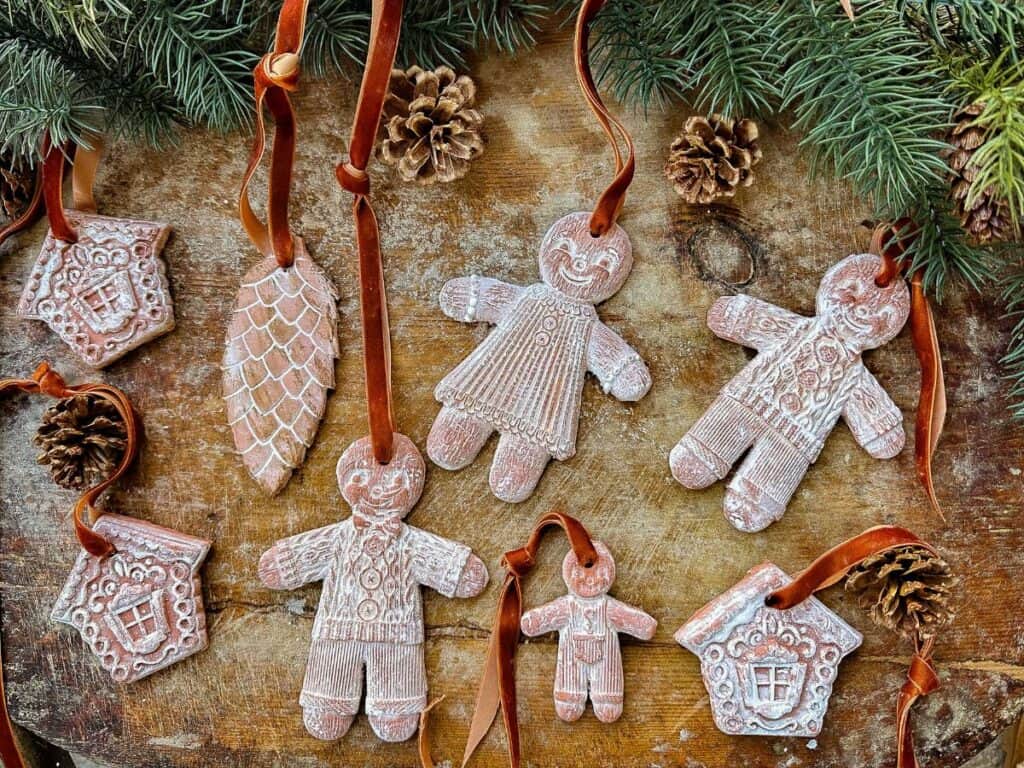 Gingerbread Air Dried Clay ornaments are lying on a cutting board.