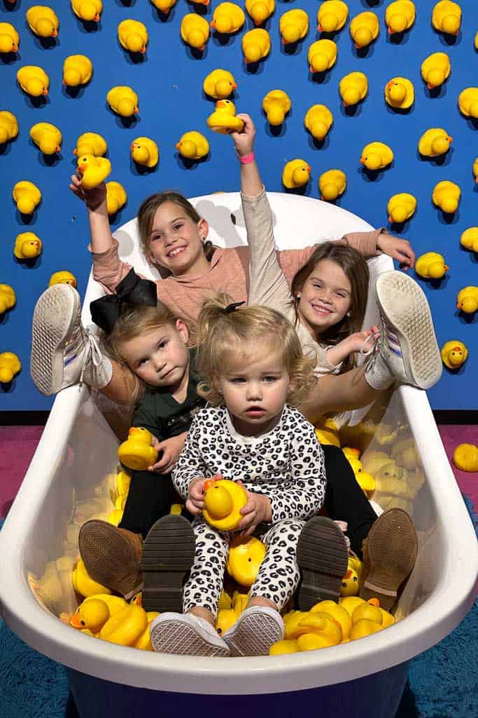 4 girls in a bathtub with rubber duckies