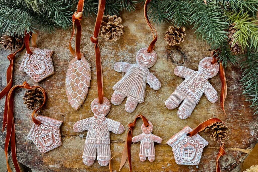 Air-dried clay gingerbread ornaments lay on a cutting board before being put on the tree.