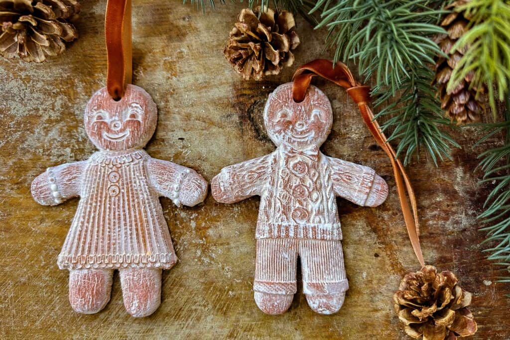 Gingerbread air dried clay ornaments sitting on a cutting board.