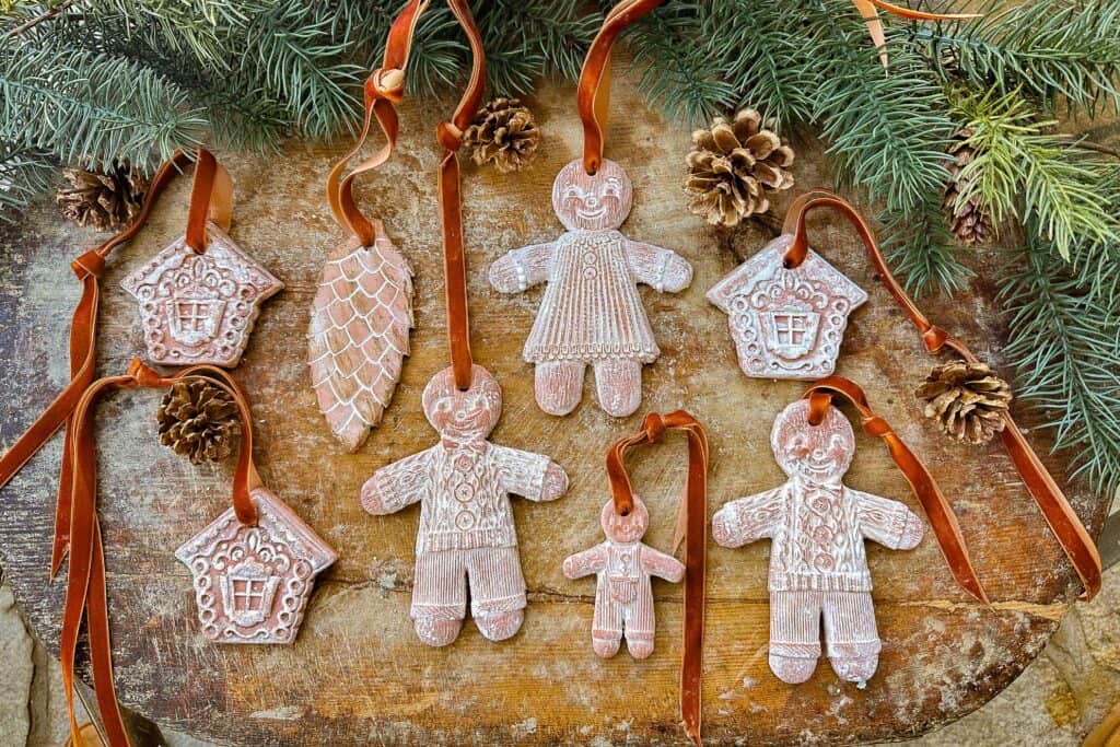 Air-dried clay gingerbread ornaments lay on a cutting board before being put on the tree.