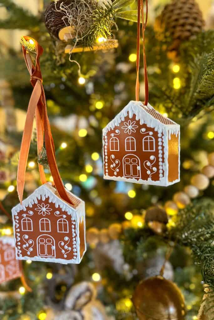 Two gingerbread ornaments hanging on the Christmas tree.