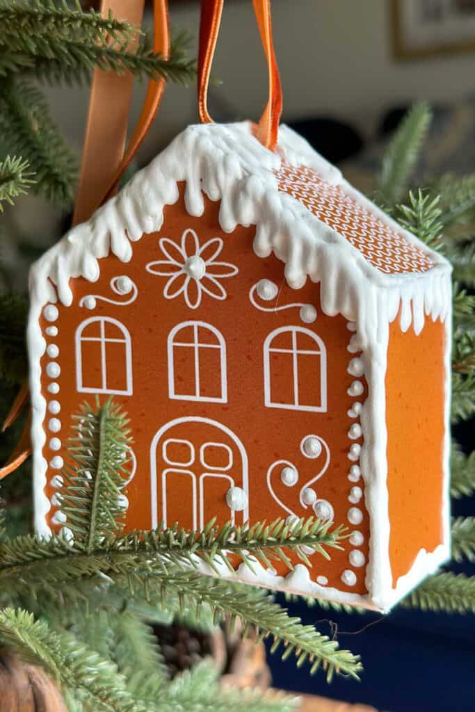 Gingerbread house with white puff paint hanging on the tree 