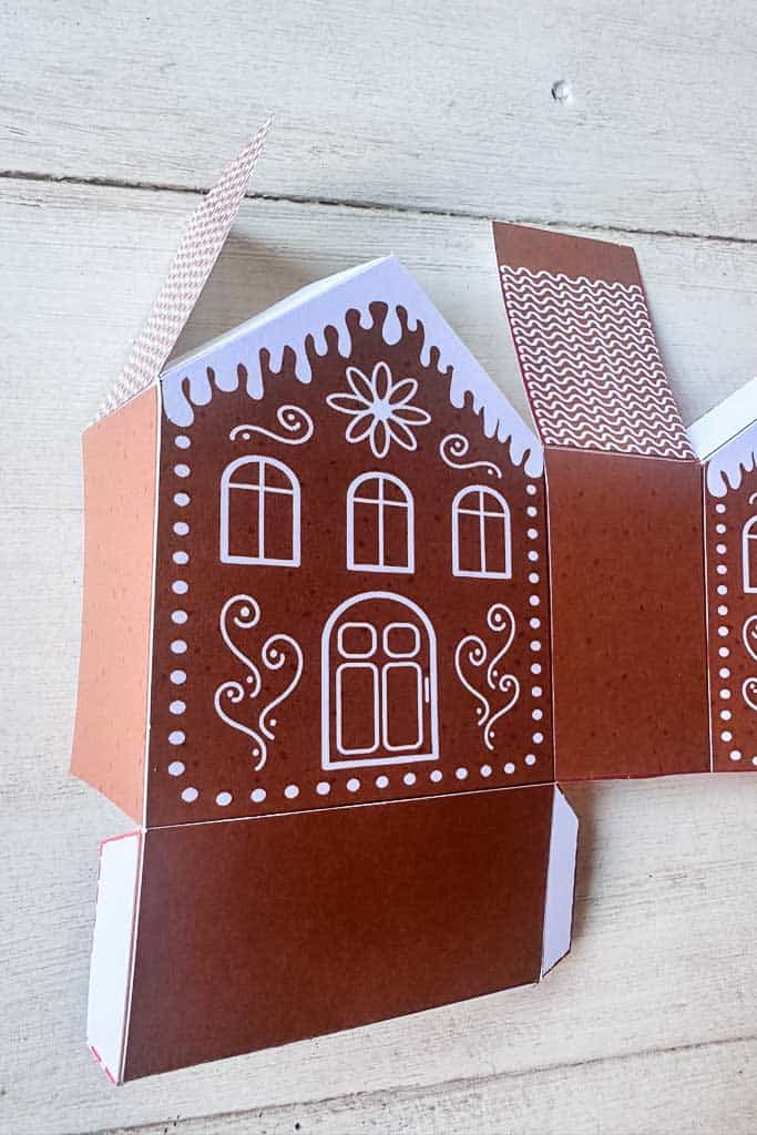Paper gingerbread house cut and folded on the black lines and ready to be glued together.