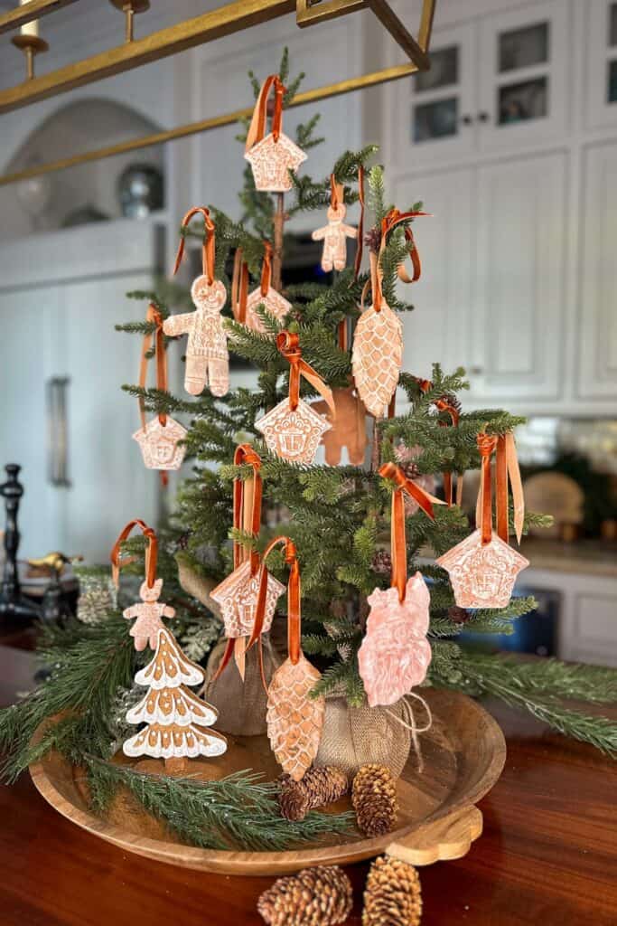 Air dried clay gingerbread ornaments hanging on a small tree in the kitchen.