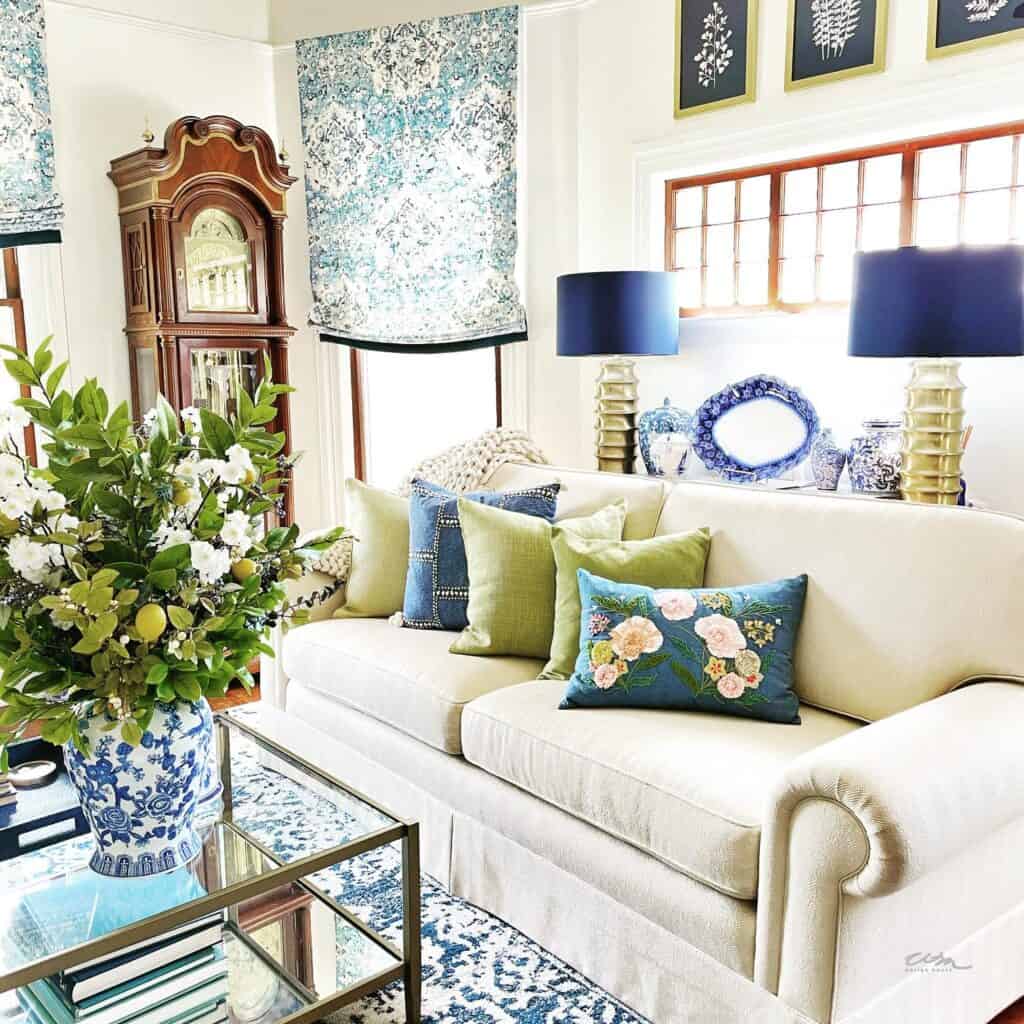 Green and blue pillows on a white couch for spring. 