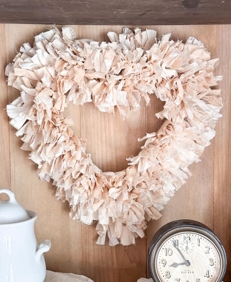 DIY Tea-dyed rag wreath hanging inside a cupboard for Valentine's Day.