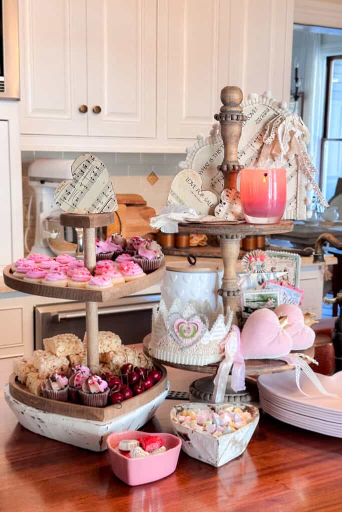 Two-tiered trays for Valentine's Day decorated with cute vintage decor and holiday treats.