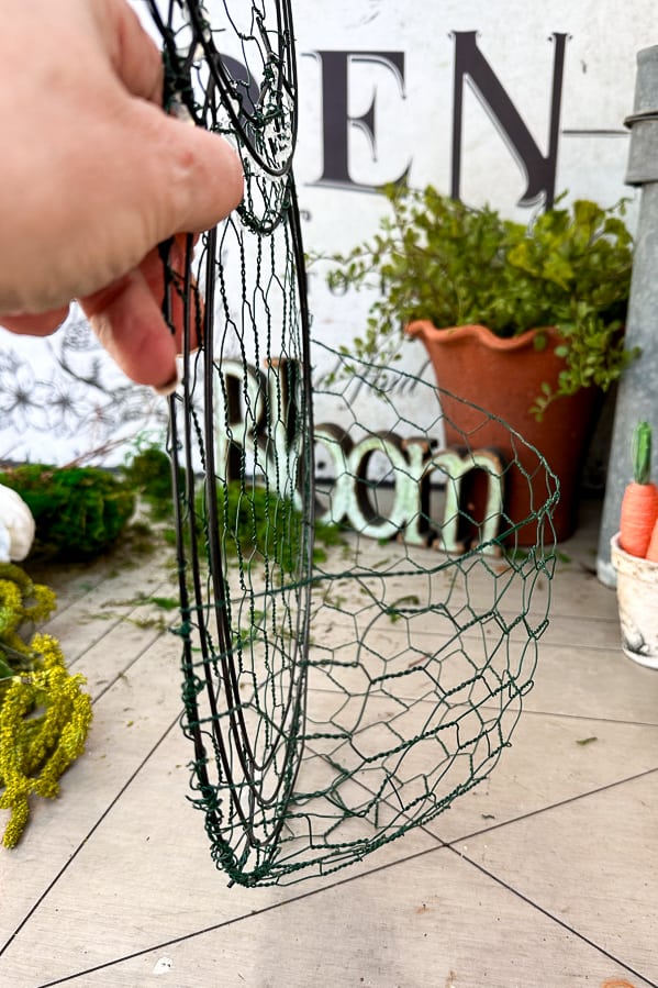 Creating a wire basket on a dollar tree egg wire wreath frame.