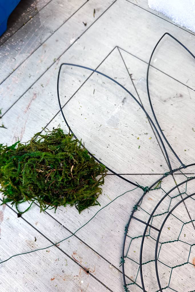 I am adding moss to the easter bunny wire wreath frame's wire frame. 