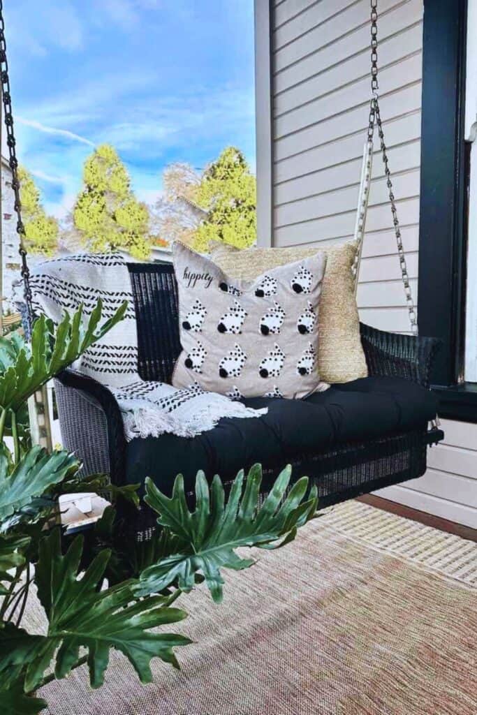 black porch swing with bunny rabbit pillows