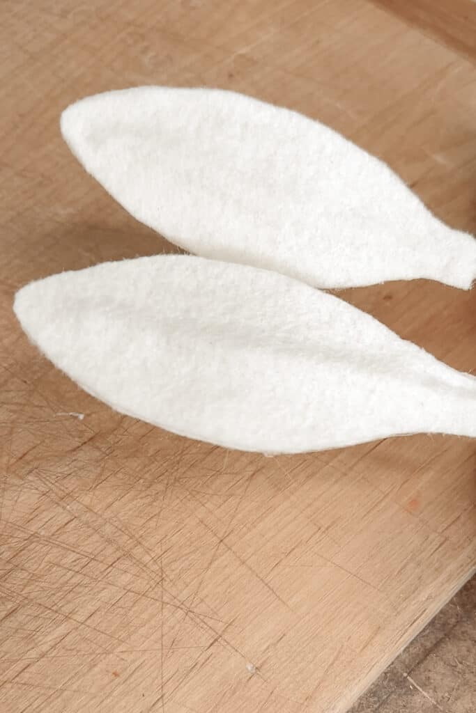 Two white felt rabbit ears preparing to make DIY napkin rings.