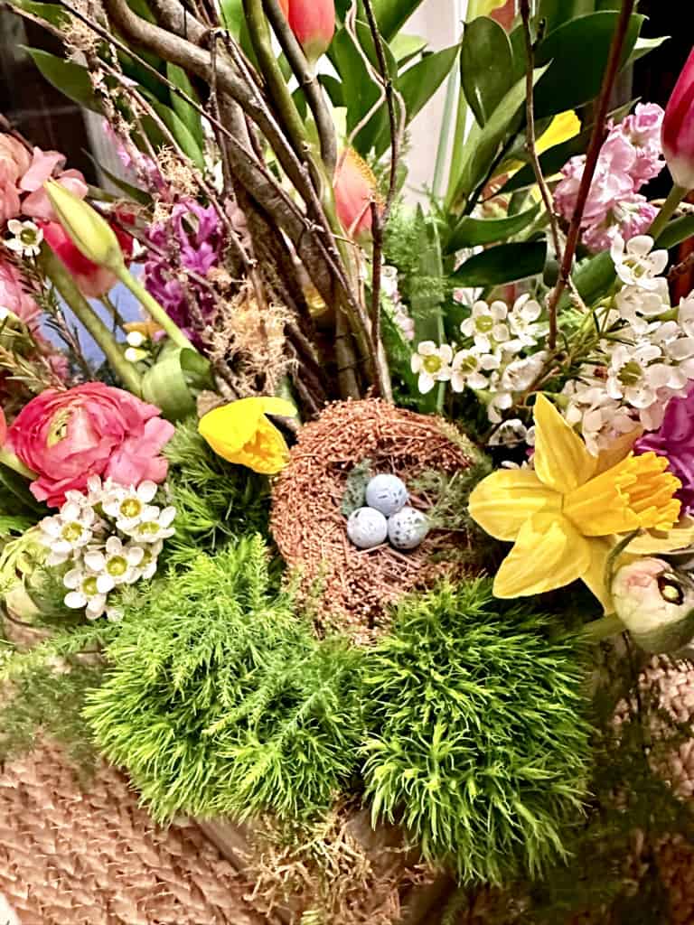 SPRING FLOWERS WITH MOSS AND A BIRDS NEST WITH EGGS 