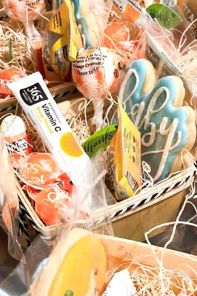 Party favor boxes with cookies, chapstick, vitamin C, and orange suckers.