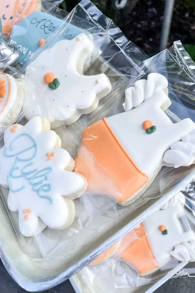 Custom-made cookies that look like bibs, bottles, onesies, and other shapes for a baby shower.