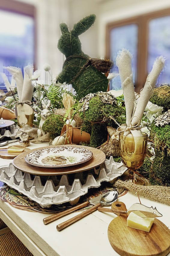 An Easter table decorated with moss rabbits and moss mushrooms. Other items that are nature inspired were added as well.