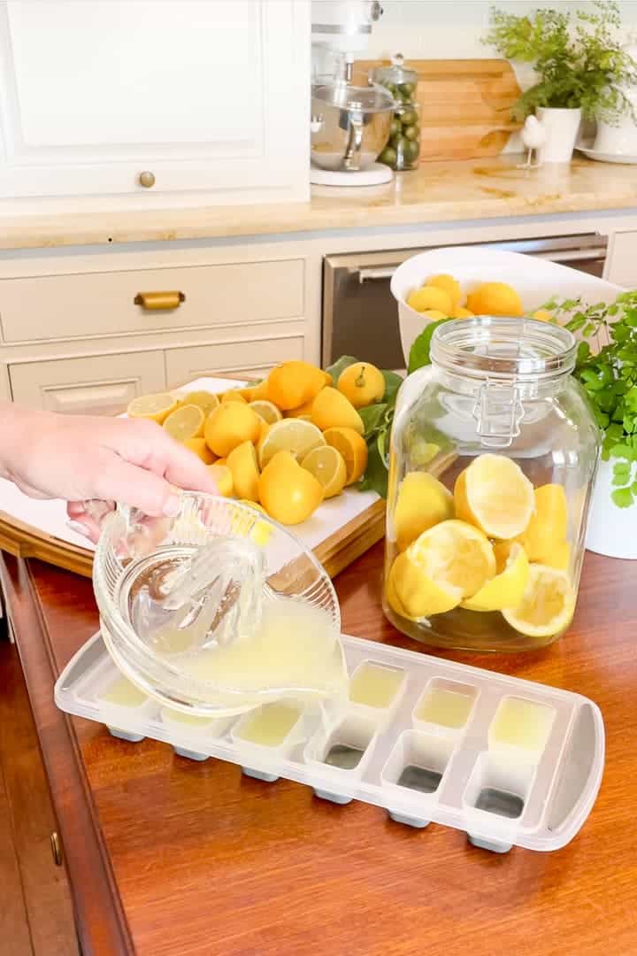 Pouring lemon juice into ice cube trays to freeze for later use.