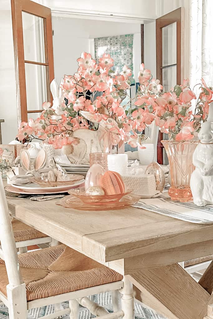 Easter table with DIY napkin rings and lots of festive decor, including pink dogwood branches. 
