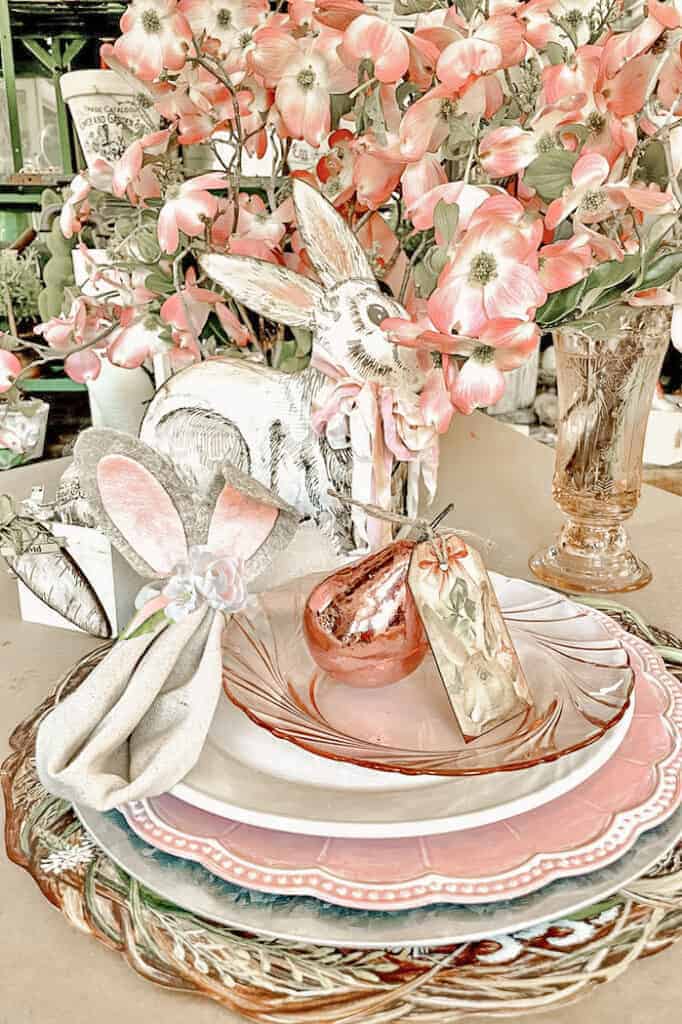 Place setting for Easter with DIY Bunny ear napkin rings and pink foil pears with a notecard.