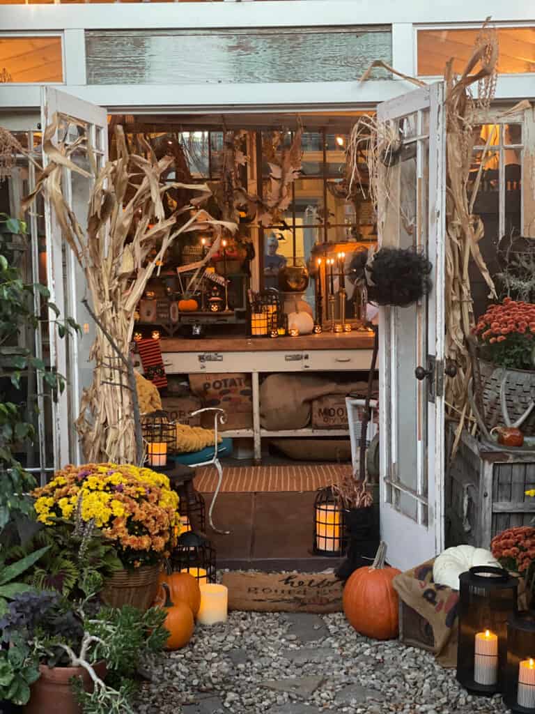 interior view of the cottage She Shed decorated with cornstalks, pumpkins, and mums for fall