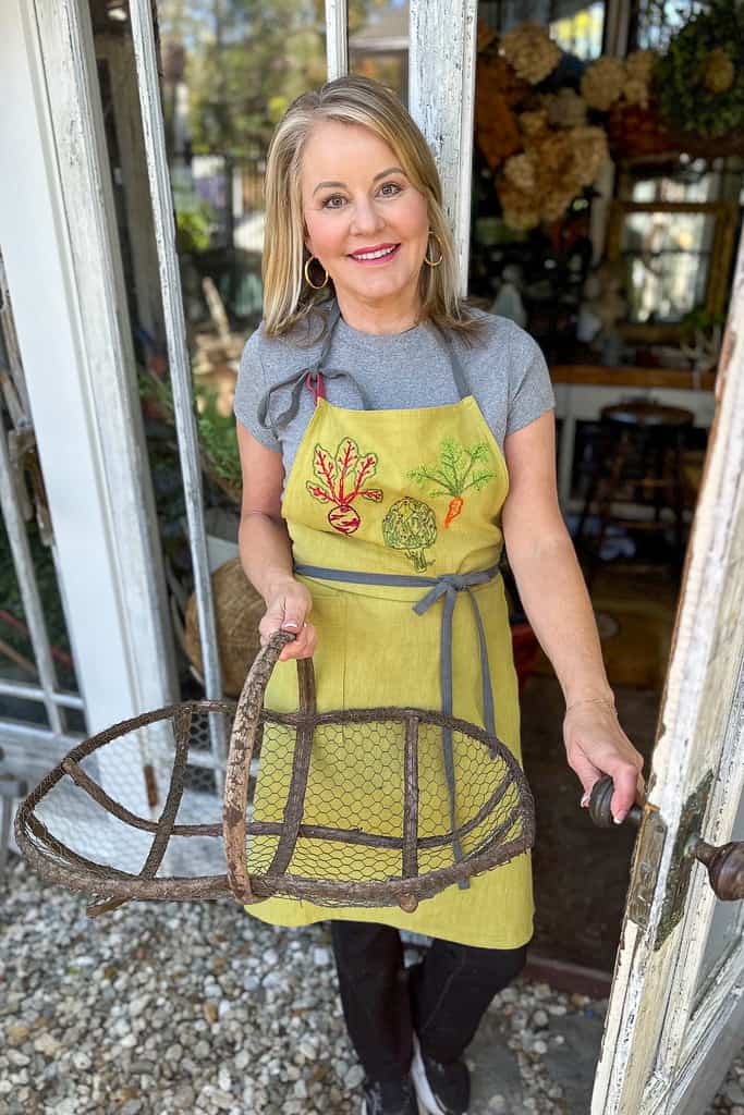 Women wearing a garden apron she embroidered with vegetables.