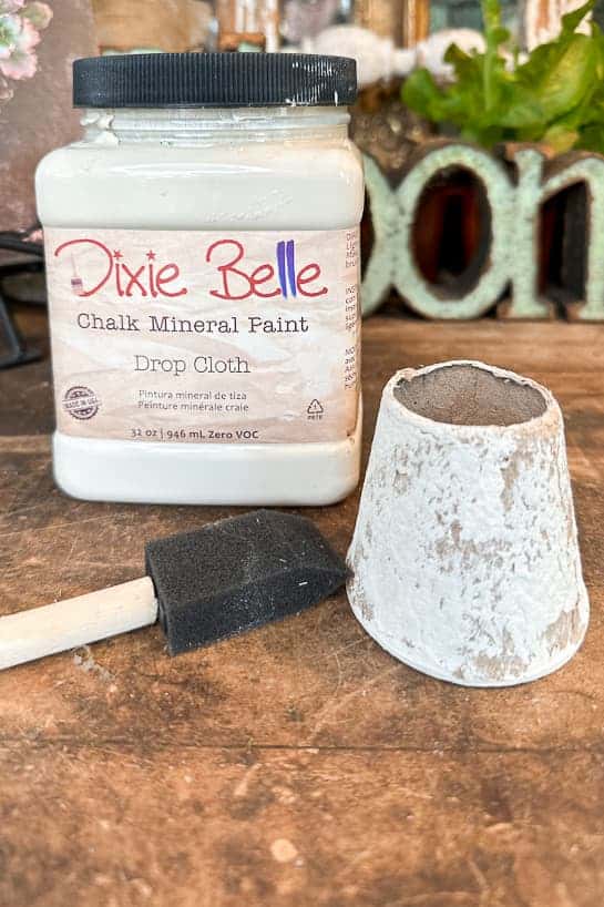 A peat pot with Dixie Belle paint and a simple foam brush to make DIY napkin rings. 