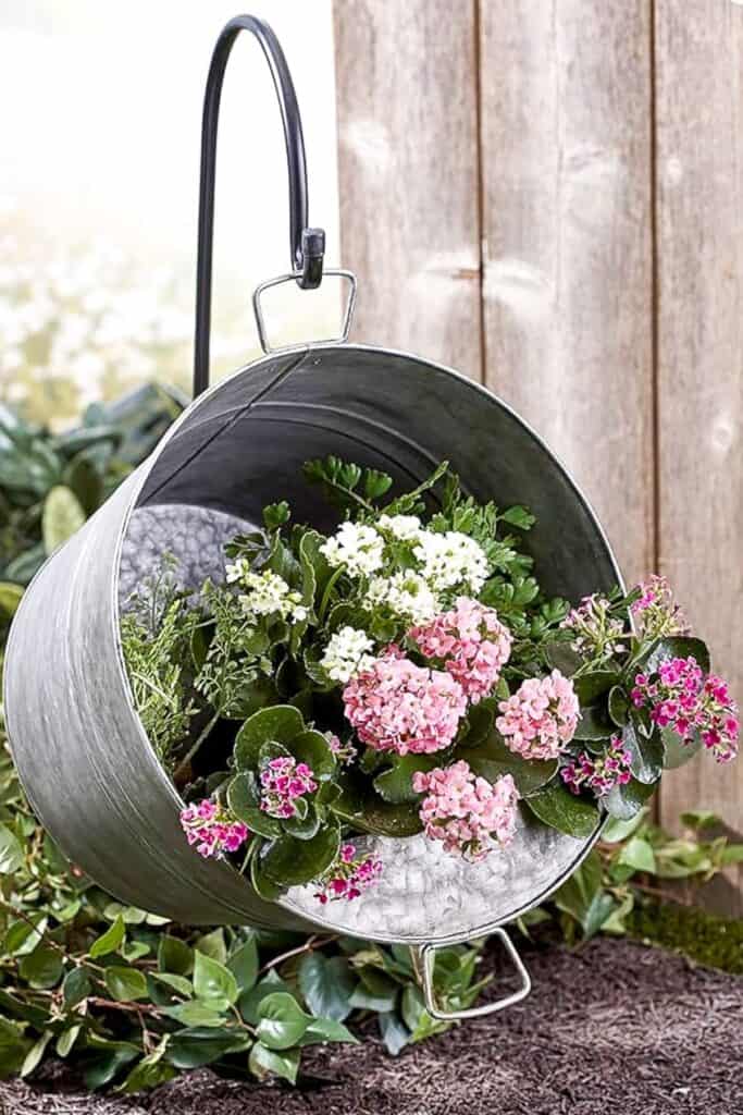 A large galvanized tub is used as a rustic planter filled with hydrangeas.