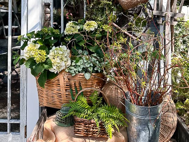 Baskets in an old wooden laundry bin full of flowers and faux greenery. 