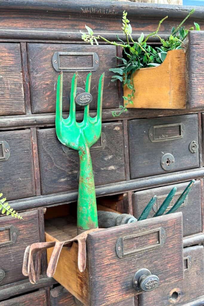 Vintage garden tools decorate a chest sitting in the California room off of the kitchen.