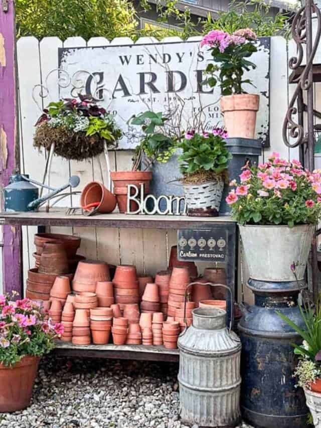 A workbench decorated with garden pots, plants, planted chairs, and more.