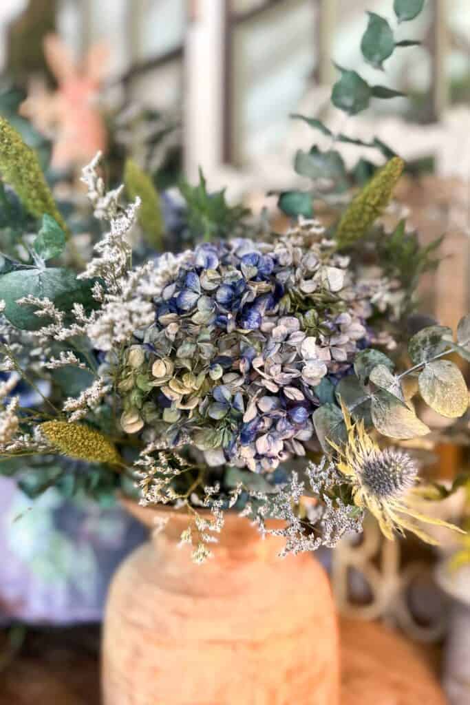 An up-close view of a dried flower arrangement using blue-dyed hydrangeas. 