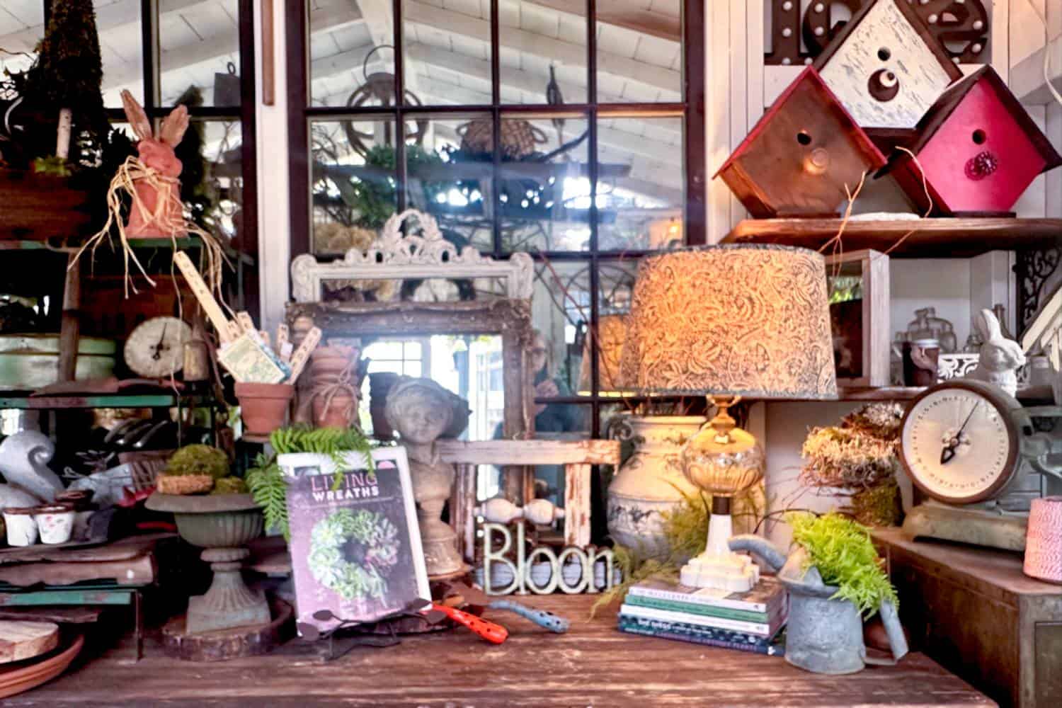 The work desk inside the She Shed styled for summer with vintage garden decor and a lamp