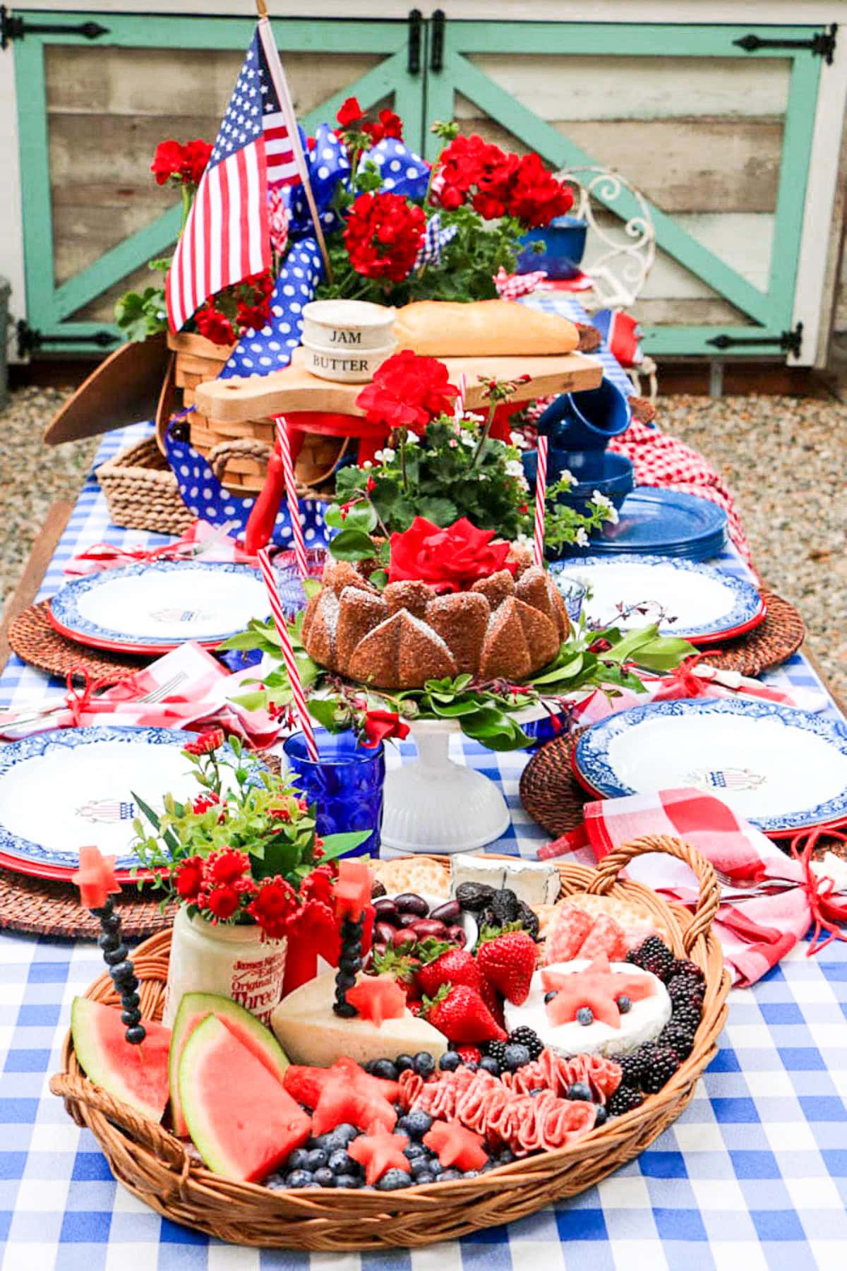 Decorating a patriotic picnic table  with American Flags, flowers, and summer bbq food