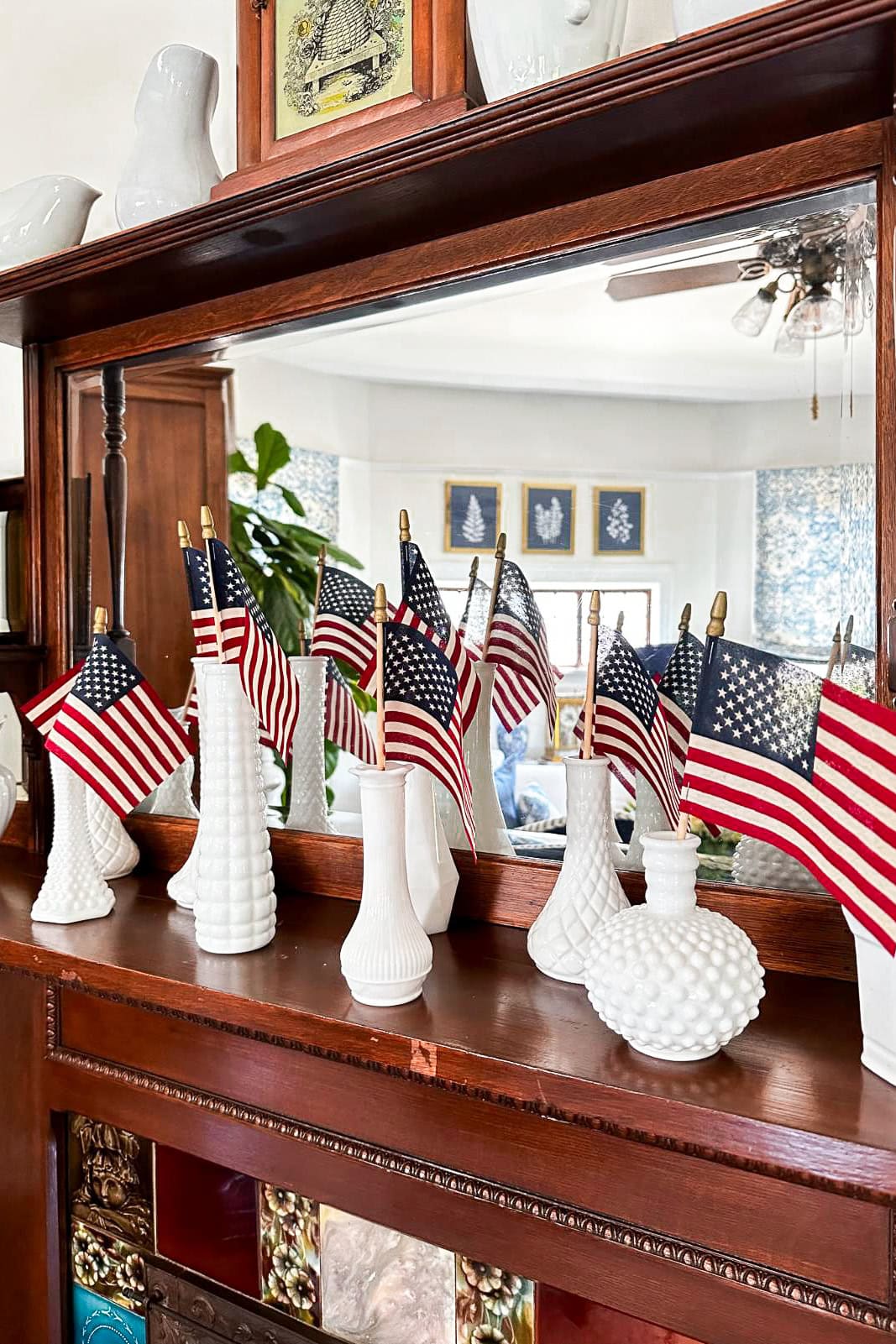 Decorating the fireplace mantel with American Flags displayed in a collection of milk glass vases