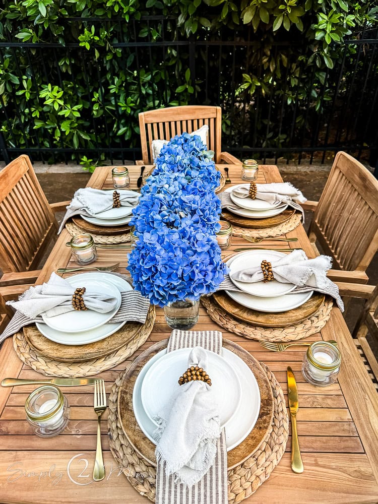 Simple Smoke It BBQ tablescape with white dishes and blue hydrangeas.